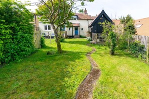 A residential property with a grassy yard, a wooden fence, and a house with a tiled roof. - 2 Bed in Wenhaston (oc-spdr) (Wenhaston)