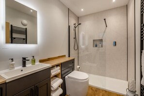 Ein modernes Badezimmer mit Dusche, Toilette und Waschtisch.