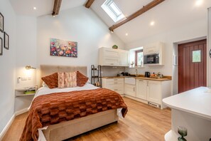 A bedroom with a bed, a painting, a nightstand, and a desk with a lamp. - 1 Bed in Wetheral (oc-g32934) (Great)