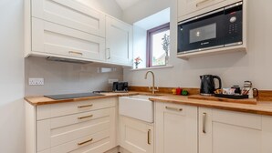 Eine moderne Küche mit weißen Schränken, einer Bosch-Mikrowelle, einem Toaster und einer Kaffeemaschine.