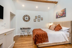 Ein Schlafzimmer mit einem Bett, einem Schreibtisch und einer Wanduhr.