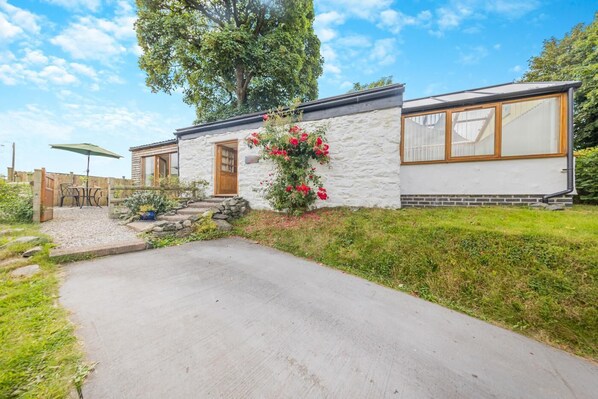 Une maison moderne avec une façade en pierre, un porche et une grande fenêtre.