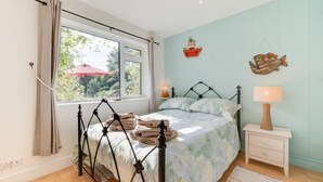 Una camera da letto con un letto, un comodino, una lampada e decorazioni a parete.