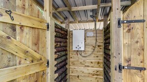 Une cabane en bois avec une porte en métal et un panneau de commande fixé au mur.