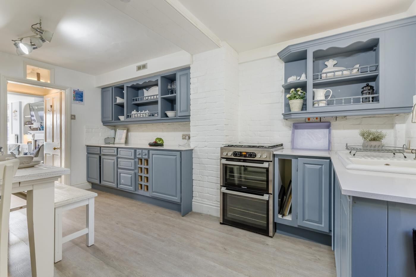 A modern kitchen with grey cabinetry, a built-in oven, and a white countertop.