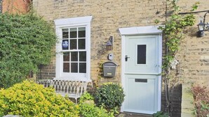 A brick house with a white window, a small shed, and a metal fence. - 1 Bed in Woodbridge (oc-jsm) (Woodbridge)