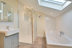A modern bathroom with a glass-enclosed shower, a large bathtub, and a skylight. - 3 Bed in Sheringham (oc-2170) (Sheringham)