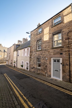 A street with stone buildings, a paved road, and double yellow lines. - 1 Bed in Jedburgh (oc-nb1951) (Jedburgh)