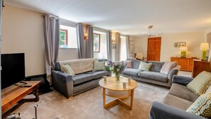 A living room with two sofas, a coffee table, a TV, and a wooden cabinet. - 4 Bed in Hawes (oc-g33122) (Hawes)