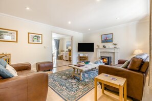 Una sala de estar con chimenea, televisor y comedor.