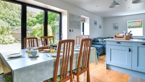 Een moderne keuken met een eethoek, houten stoelen en een ontbijttafel.