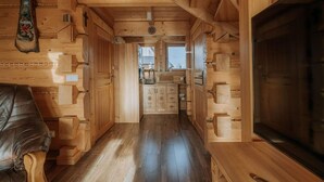 Un intérieur en bois avec un canapé, des placards et un téléviseur.