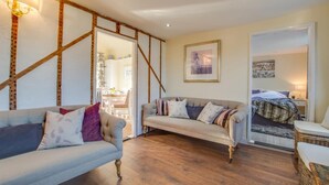 A cozy living room with two sofas, a dining area, and a bedroom with a bed and nightstand. - 2 Bed in Peasmarsh (oc-rh1172) (Peasmarsh)