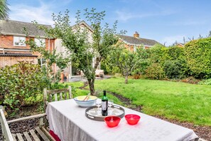 A patio with a table set for two, a bottle, and a glass. - 3 Bed in Milford On Sea (oc-f33344) (Milford on Sea)