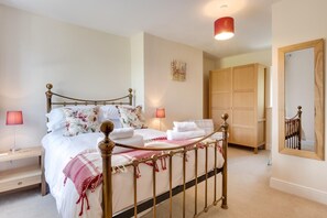 A bedroom with a bed, bedside lamps, a wooden wardrobe, and a mirror. - 2 Bed in Hawes (oc-ds052) (Hawes)