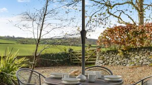 An outdoor dining area with a table set for two, surrounded by chairs, under a canopy. - 2 Bed in Bodmin (oc-p00378) (Trevisquite Manor)