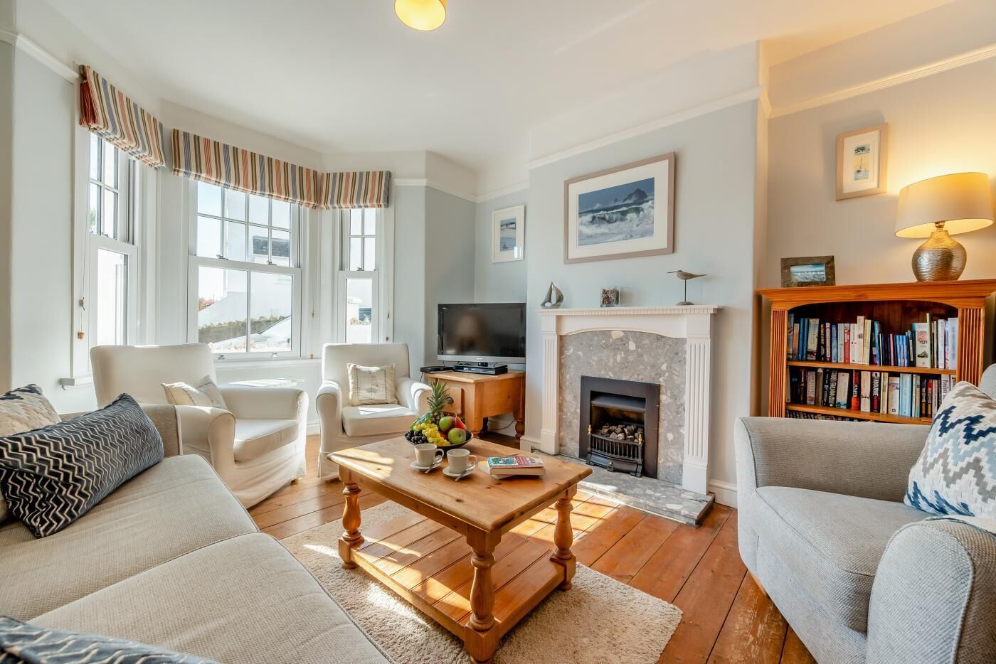 A living room with a fireplace, a television, and a bookshelf.