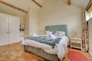 Ein Schlafzimmer mit einem großen Bett, einem Nachttisch, einem Kleiderschrank und einem Bücherregal.