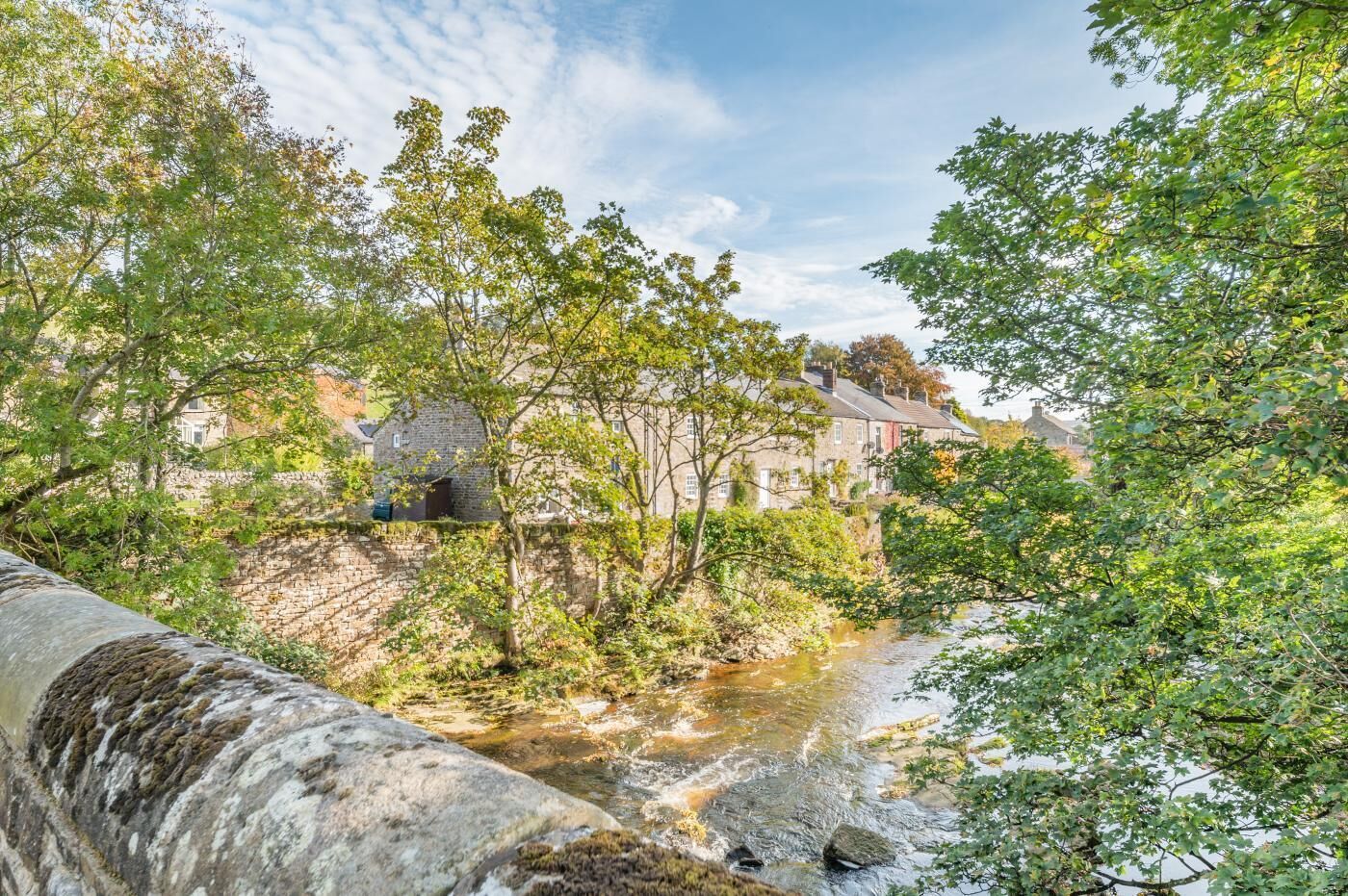 Un ponte di pietra sopra un fiume, con edifici sullo sfondo.