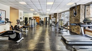 Uma academia com esteiras, elípticos e equipamentos de musculação.