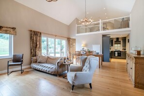 A spacious living area with a sofa, armchair, and dining table. A kitchen is visible in the background. - 1 Bed in Twyford (oc-c33411) (Twyford)