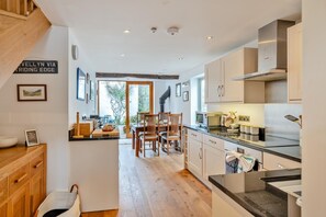 A modern kitchen with wooden cabinets, a dining area with chairs, and a view of the outdoors. - 2 Bed in Troutbeck (oc-c33392) (Troutbeck)