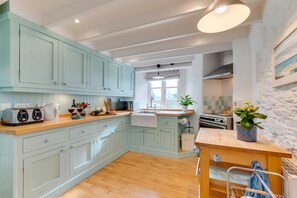 A kitchen with light blue cabinets, a wooden countertop, a stove, and a sink. - 2 Bed in Bere Alston (oc-bctang) (Bere Alston)