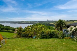 A coastal landscape with a view of the sea, greenery, and a building with a blue fence. - 2 Bed in Bere Alston (oc-bctang) (Bere Alston)