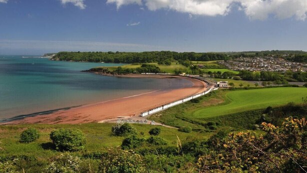 A coastal landscape with a beach, a golf course, and a small settlement. - 2 Bed in Paignton (oc-h28353) (Paignton)