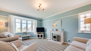 A living room with a television, fireplace, and two sofas. - 2 Bed in Paignton (oc-h28353) (Paignton)