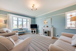 A living room with a television, fireplace, and two sofas. - 2 Bed in Paignton (oc-h28353) (Paignton)