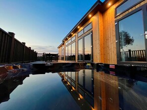 Ein modernes Gebäude mit großen Fenstern und einem glitzernden Pool.