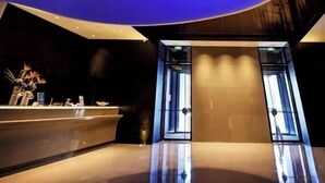A modern interior with a curved ceiling and a large window displaying a view of Jupiter. - Beijing Bolly Wood Hotel-Guomao SKP  (Beijing)