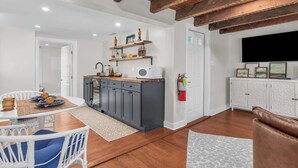 A modern kitchen with dark grey cabinets, a wooden ceiling, and a white countertop. - Downtown St. Michaels | Porch + Pet-Friendly (Saint Michaels)