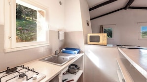 A compact kitchen with a gas stove, sink, and a microwave. - Villa "Lavezzi" 35m² - 2/4 pers, Rondinara, Bonifacio (Bonifacio)