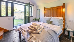 Quarto com cama, mesa de cabeceira, janela e vista para o exterior.