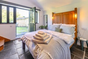 A bedroom with a bed, a bedside table, a window, and a view of the outdoors. - 1 Bed in St. Austell (oc-b33396) (Pentewan Valley)