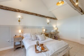 A bedroom with a large bed, bedside tables, lamps, and a tray with cups and a teapot. - 7 Bed in Ellough (oc-g33283) (Ellough)