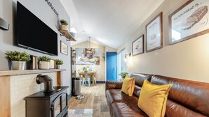 Ein modernes Wohnzimmer mit Kamin, Ledersofa und Flachbildfernseher.