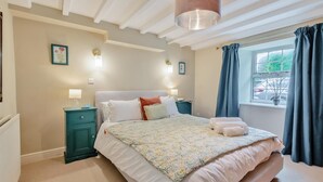 A bedroom with a bed, nightstands, a lamp, a window with curtains, and a ceiling light fixture. - 4 Bed in Ellonby (oc-y33284) (Ellonby)
