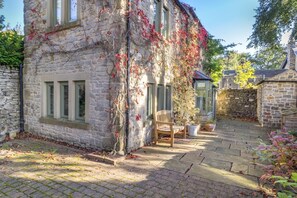 Ein Gebäude aus Stein mit einer Bank und Pflanzkübeln im Innenhof.