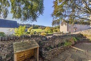 A stone wall with a wooden structure, a stone pathway, and a building in the background. - 3 Bed in Calver (oc-h33087) (Calver)