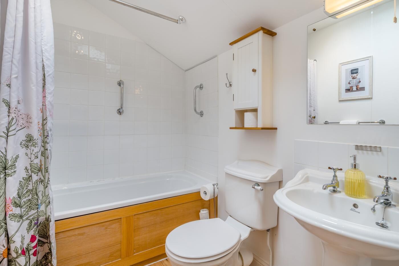 A bathroom with a bathtub, toilet, sink, and a shower area.