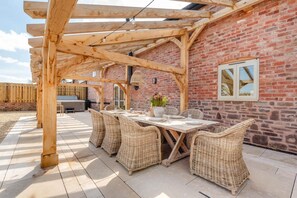 A covered outdoor dining area with wicker furniture and a brick wall. - 4 Bed in Moccas (oc-r33127) (Moccas)