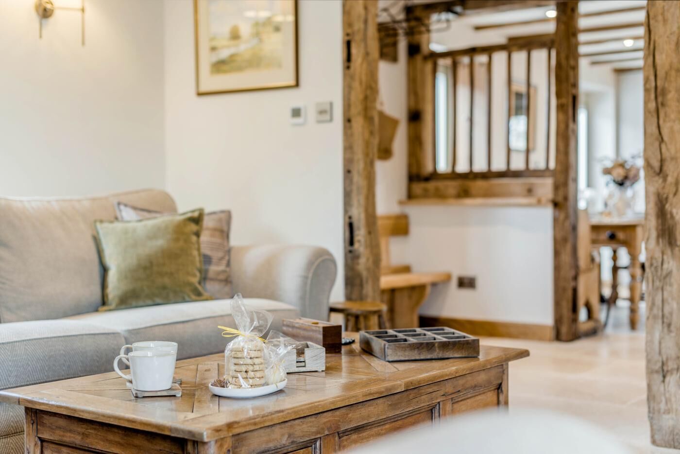 A cozy living room with a wooden coffee table, a sofa, and a staircase.
