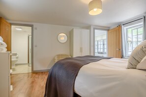 Une chambre à coucher avec un lit, une armoire, un miroir et une fenêtre.