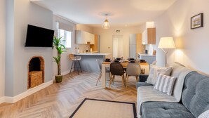 A modern apartment with a dining area, kitchen, and living room. - 3 Bed in Shanklin (oc-h33403) (Shanklin)