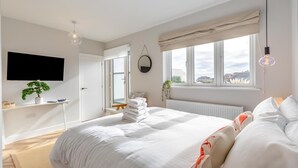 A modern bedroom with a bed, a TV, a window, and a plant. - 3 Bed in Shanklin (oc-h33403) (Shanklin)