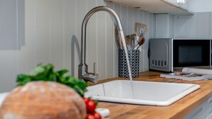 Een magnetron, een oven, een vaatwasser, kookgerei, borden en bestek