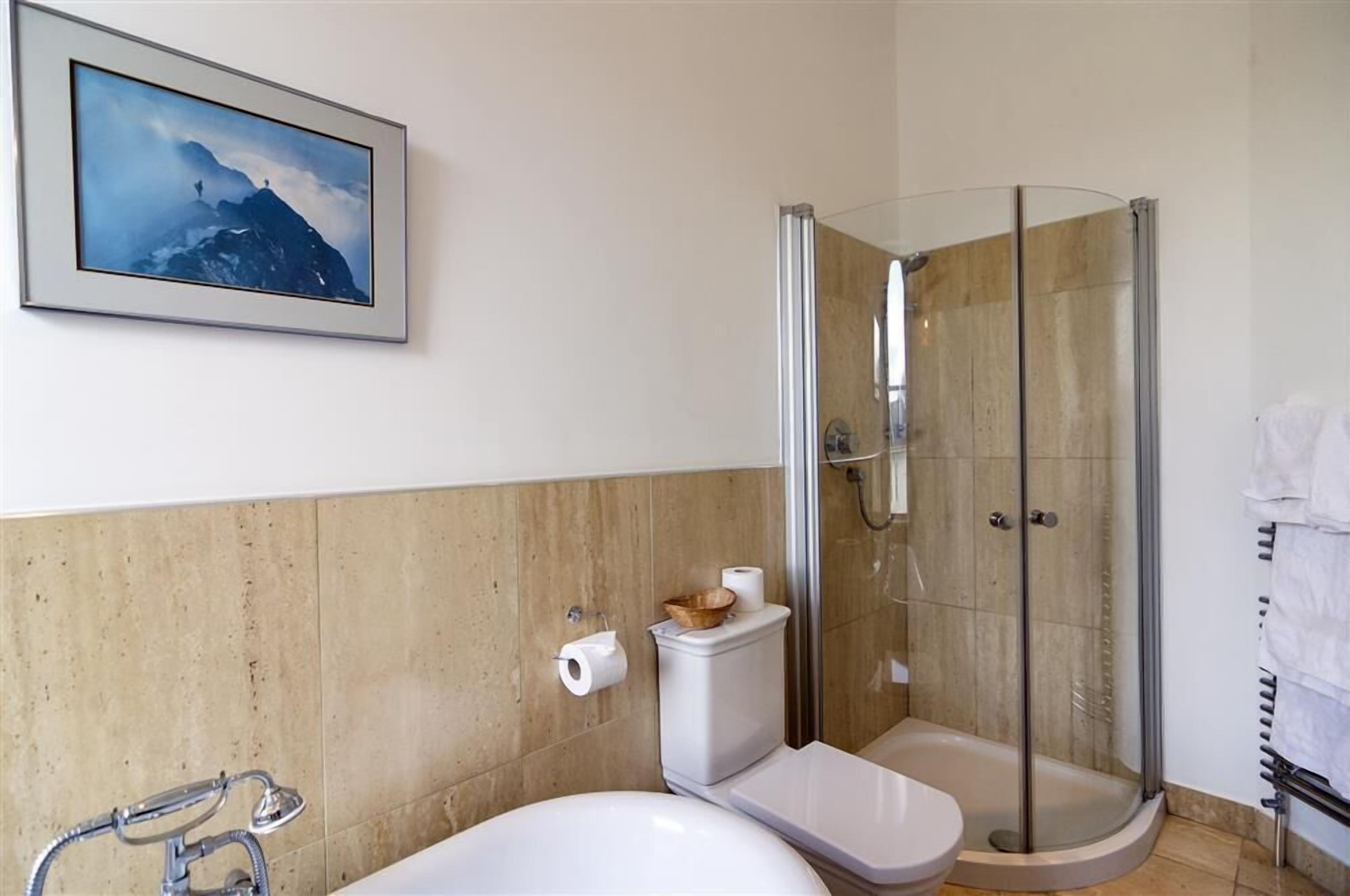 A bathroom with a shower, toilet, and sink.